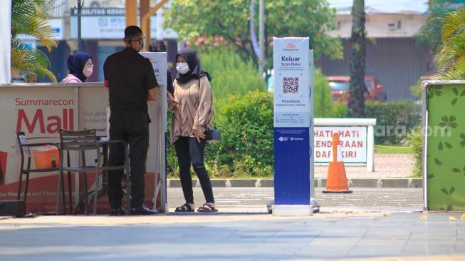 Petugas memeriksa aplikasi peduli lindungi pengunjung di Summarecon Mal Serpong. Tangerang Selasa (7/9)( Suara.com/ Hilal Rauda Fiqry)