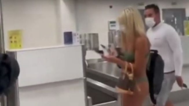 Viral wanita pakai bikini di bandara. Dia jalan santai bawa tas. Video itu viral di media sosial.