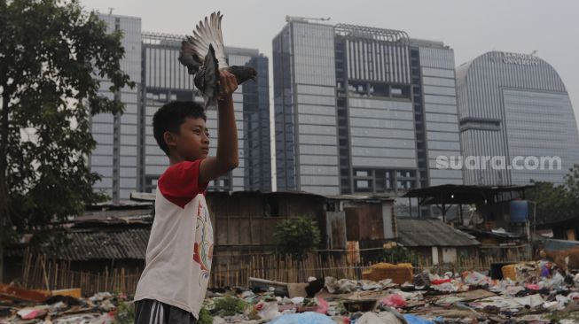 Seorang anak bermain burung di Pancoran Buntu 2, Jakarta, Selasa (7/9/2021). [Suara.com/Angga Budhiyanto]