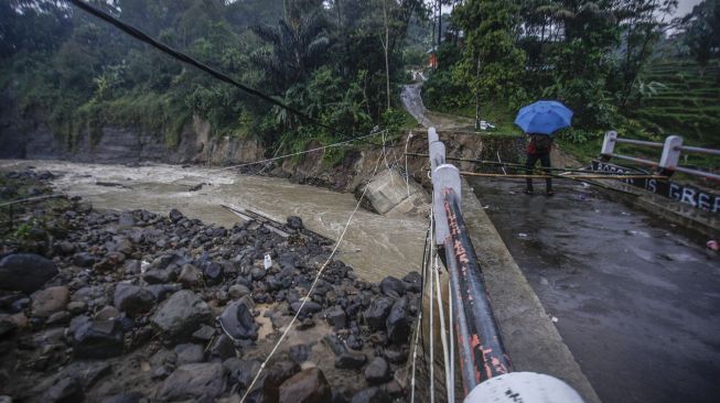 Warga melihat kondisi jembatan perbatasan Kecamatan Sukajaya dan Kecamatan Nanggung yang terputus di Desa Urug, Sukajaya, Kabupaten Bogor, Jawa Barat, Selasa (7/9/2021). ANTARA FOTO/Yulius Satria Wijaya