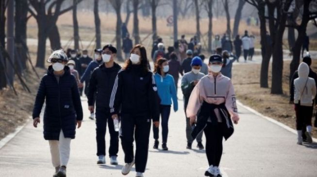 Dokumentasi - Warga memakai masker berjalan-jalan di Hanriver Park, Seoul, Korea Selatan, Februari 2021[ANTARA]