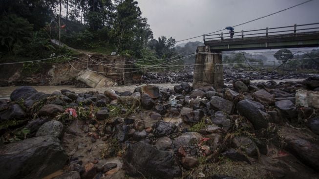 Warga melihat kondisi jembatan perbatasan Kecamatan Sukajaya dan Kecamatan Nanggung yang terputus di Desa Urug, Sukajaya, Kabupaten Bogor, Jawa Barat, Selasa (7/9/2021). ANTARA FOTO/Yulius Satria Wijaya