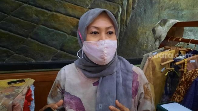 Dwi Wulandari, pelaku usaha kain ecoprint, menata hasil karyanya pada Pameran Bersama IKM di Aula Pandawa, Kompleks Balai Kota Yogyakarta,  Selasa (7/9/2021). - (SuaraJogja.id/Muhammad Ilham Baktora)