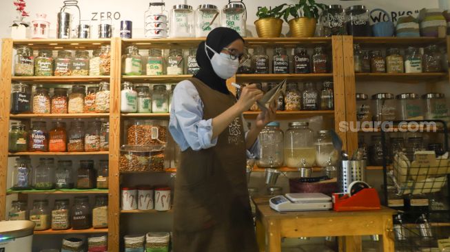 Karyawan toko menulis barang dagangan yang sudah dibeli di Toko Naked Inc, Kemang, Jakarta Selatan, Kamis (9/9/2021). [Suara.com/Alfian Winanto]