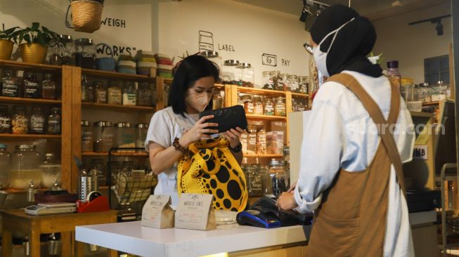 Pembeli membayat belanjaan yang akan dibelinya di Toko Naked Inc, Kemang, Jakarta Selatan, Kamis (9/9/2021). [Suara.com/Alfian Winanto]