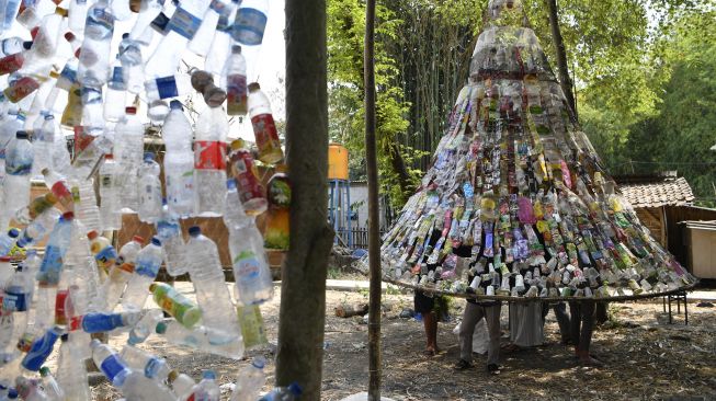 Relawan mengaitkan botol plastik bekas saat pembuatan instalasi Museum Plastik di Ecological Observation and Wetlands Conservation (Ecoton) di Gresik, Jawa Timur, Kamis (9/9/2021).  ANTARA FOTO/Zabur Karuru