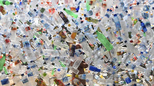 Relawan mengaitkan botol plastik bekas saat pembuatan instalasi Museum Plastik di Ecological Observation and Wetlands Conservation (Ecoton) di Gresik, Jawa Timur, Kamis (9/9/2021).  ANTARA FOTO/Zabur Karuru