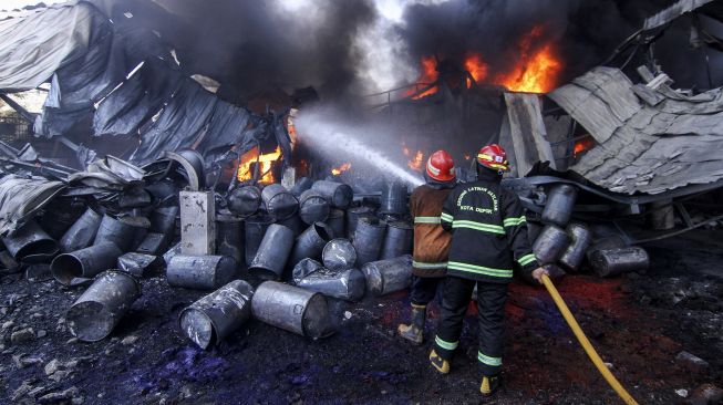 Petugas damkar berusaha memadamkan api yang membakar sebagian gudang di Pabrik Karung, Sukatani, Depok, Jawa Barat, Jumat (10/9/2021).  ANTARA FOTO/Asprilla Dwi Adha
