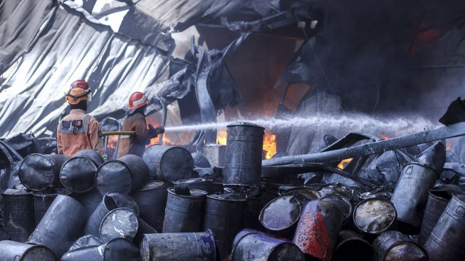 Petugas damkar berusaha memadamkan api yang membakar sebagian gudang di Pabrik Karung, Sukatani, Depok, Jawa Barat, Jumat (10/9/2021).  ANTARA FOTO/Asprilla Dwi Adha
