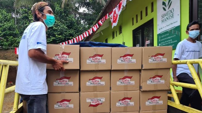 Penyerahan bantuan paket bahan pokok kepada warga kurang mampu yang terdampak pandemi di Kampung Berseri Astra (KBA) Kedungwaringin, Bekasi, Jawa Barat. Nurani Astra secara bertahap mendistribusikan paket bantuan tersebut ke berbagai wilayah di Indonesia [Astra International Tbk.,]