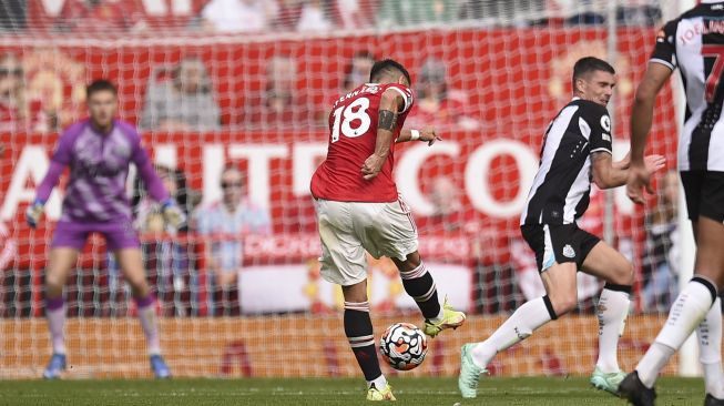 Gelandang Manchester United Bruno Fernandes (tengah) melakukan tembakan selama pertandingan sepak bola Liga Premier Inggris antara Manchester United dan Newcastle di Old Trafford, Manchester, Inggris, Sabtu (11/9/2021). [Oli SCARFF / AFP]