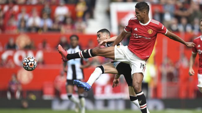 Gelandang Newcastle United Miguel Almiron (kiri) bersaing dengan bek Manchester United Raphael Varane (kanan) selama pertandingan sepak bola Liga Premier Inggris antara Manchester United dan Newcastle di Old Trafford, Manchester, Inggris, Sabtu (11/9/2021). [Oli SCARFF / AFP]