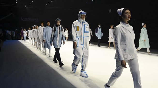 Para model berlatih sebelum menampilkan kreasi untuk koleksi 'Heroes in Harm's Way' oleh Beijing Institute of Fashion Technology dan Dishang Group selama China Fashion Week di Beijing, Cina, pada (11/9/2021). [Jade GAO / AFP]