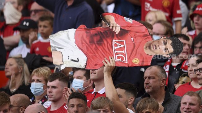 Seorang pendukung memegang replika striker Manchester United Cristiano Ronaldo selama pertandingan sepak bola Liga Premier Inggris antara Manchester United dan Newcastle di Old Trafford, Manchester, Inggris, Sabtu (11/9/2021). [Oli SCARFF / AFP]