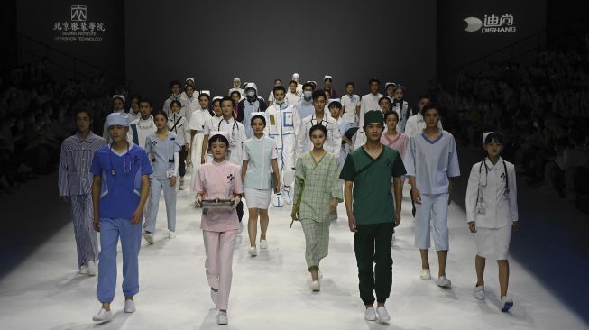 Model menampilkan kreasi untuk koleksi 'Heroes in Harm's Way' oleh Beijing Institute of Fashion Technology dan Dishang Group selama China Fashion Week di Beijing, Cina, pada (11/9/2021). [Jade GAO / AFP]