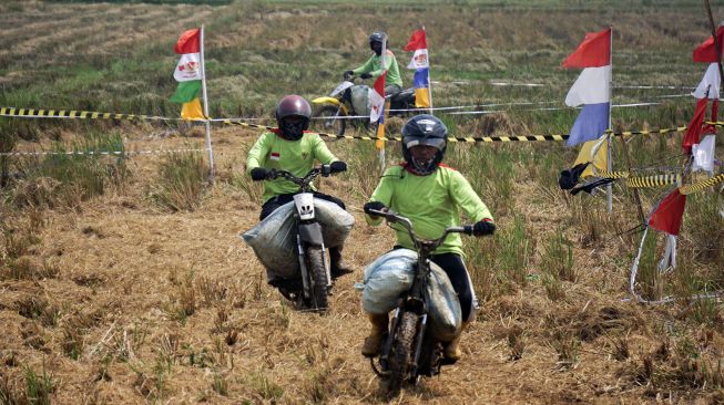 Sejumlah warga mengikuti balap sepeda motor gabah di lahan sawah milik warga di Desa Tegalsari, Kandeman, Kabupaten Batang, Jawa Tengah, Minggu (12/9/2021). [ANTARA FOTO/Harviyan Perdana Putra]