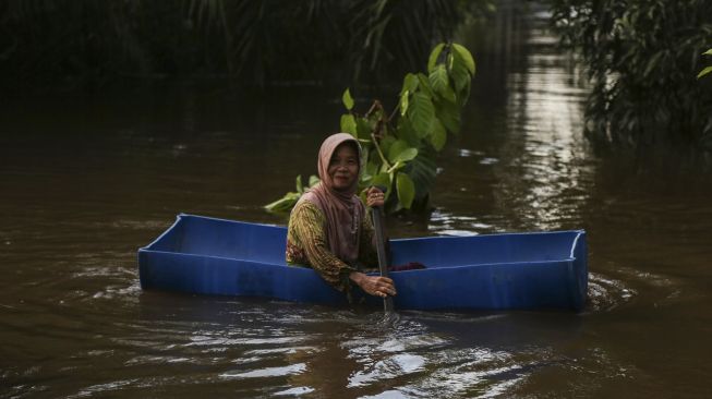 Warga menggunakan perahu seadanya untuk melintasi banjir sekitar permukiman rumahnya di Desa Petak Bahandang, Kabupaten Katingan, Kalimantan Tengah, Sabtu (11/9/2021). [ANTARA FOTO/Makna Zaezar]