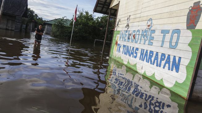 Warga menerobos banjir yang merendam permukiman sekitar rumahnya di Desa Petak Bahandang, Kabupaten Katingan, Kalimantan Tengah, Sabtu (11/9/2021). [ANTARA FOTO/Makna Zaezar]