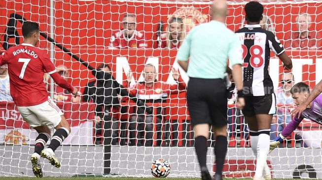 Striker Manchester United Cristiano Ronaldo (kiri) bersiap untuk mencetak gol pembuka pertandingan sepak bola Liga Premier Inggris antara Manchester United dan Newcastle di Old Trafford, Manchester, Inggris, Sabtu (11/9/2021). [Oli SCARFF / AFP]