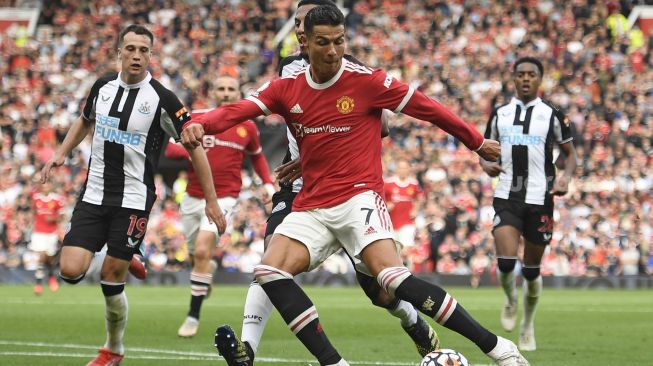 Striker Manchester United Cristiano Ronaldo menembak untuk mencetak gol kedua mereka selama pertandingan sepak bola Liga Premier Inggris antara Manchester United dan Newcastle di Old Trafford, Manchester, Inggris, Sabtu (11/9/2021). [Oli SCARFF / AFP]