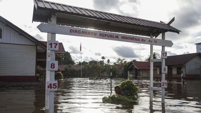 Warga menerobos banjir yang merendam permukiman sekitar rumahnya di Desa Petak Bahandang, Kabupaten Katingan, Kalimantan Tengah, Sabtu (11/9/2021). [ANTARA FOTO/Makna Zaezar]