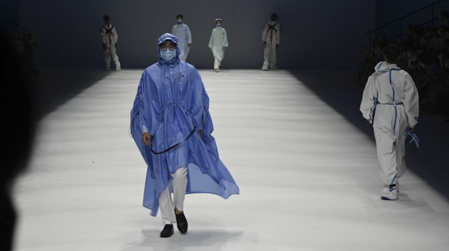 Model menampilkan kreasi untuk koleksi 'Heroes in Harm's Way' oleh Beijing Institute of Fashion Technology dan Dishang Group selama China Fashion Week di Beijing, Cina, pada (11/9/2021). [Jade GAO / AFP]