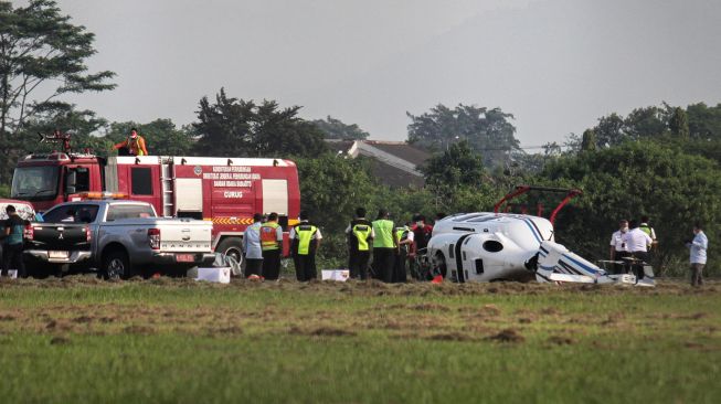 Sejumlah petugas melakukan evakuasi terhadap helikopter tipe Bell 429 PK-CAW milik Balai Besar Kalibrasi Fasilitas Penerbangan Kemeterian Perhubungan di landasan Bandara Budiarto, Curug, Kabupaten Tangerang, Banten, Senin (13/9/2021).  ANTARA FOTO/Fauzan