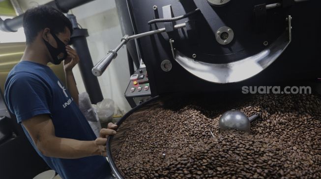 Pekerja melakukan proses pemanggangan biji kopi (roasting) di tempat produksi Dunia Kopi, Pasar Santa, Jakarta, Selasa (14/9/2021). [Suara.com/Angga Budhiyanto]