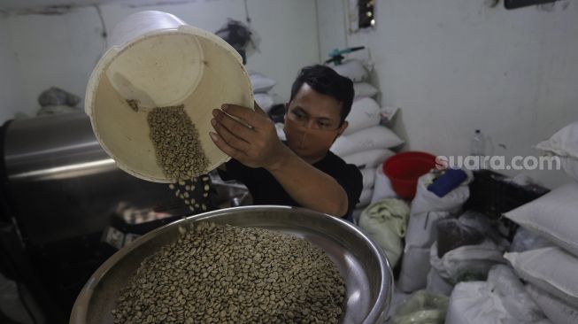 Pekerja melakukan proses pemanggangan biji kopi (roasting) di tempat produksi Dunia Kopi, Pasar Santa, Jakarta, Selasa (14/9/2021). [Suara.com/Angga Budhiyanto]