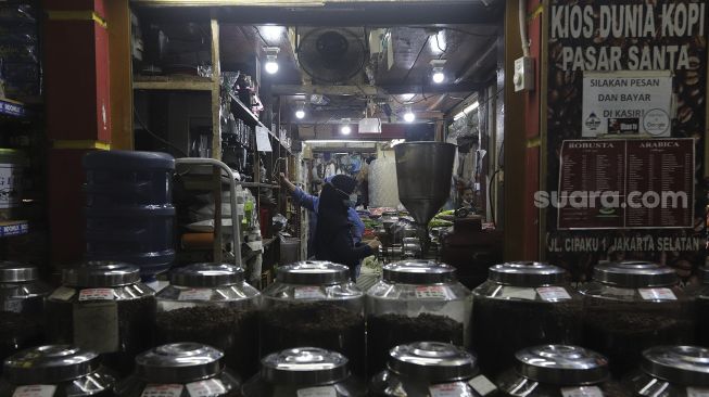 Pekerja melayani pembeli di kios Dunia Kopi, Pasar Santa, Jakarta, Selasa (14/9/2021). [Suara.com/Angga Budhiyanto]