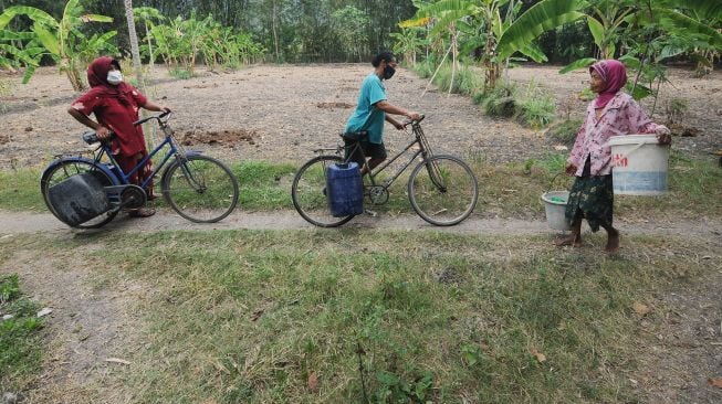 Warga membawa jeriken berisi air dengan sepeda saat mencari air bersih di Sawit, Ngerangan, Bayat, Klaten, Jawa Tengah, Selasa (14/9/2021). ANTARA FOTO/Aloysius Jarot Nugroho
