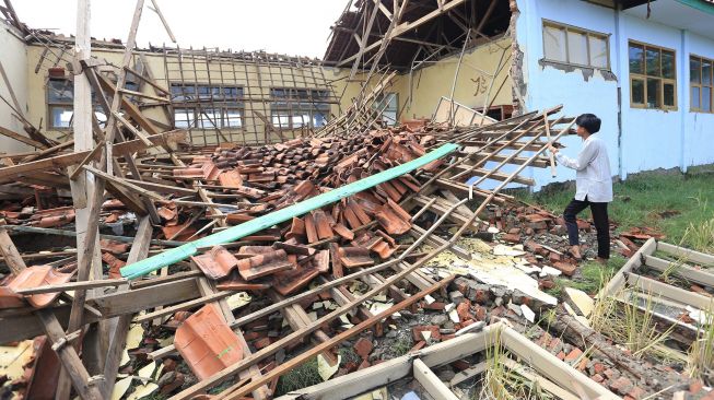 Seorang warga melihat reruntuhan bangunan laboratorium biologi yang ambruk di SMAN 1 Lelea, Indramayu, Jawa Barat, Rabu (15/9/2021).  ANTARA FOTO/Dedhez Anggara