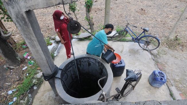 Warga mengisi air ke dalam jeriken saat mencari air bersih di Sawit, Ngerangan, Bayat, Klaten, Jawa Tengah, Selasa (14/9/2021).  ANTARA FOTO/Aloysius Jarot Nugroho