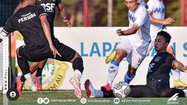 Pemain PSCS Cilacap Thauvan Hidayat melewati pemain Persiba Balikpapan dalam uji coba di Jakarta. [PSCS Cilacap]