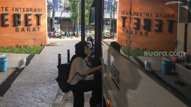 Penumpang menaiki bus Transjakarta di halte integrasi sisi barat Stasiun Tebet, Jakarta Selatan, Kamis (16/9/2021). [Suara.com/Alfian Winanto]