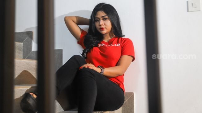 Peserta Finalis Miss Popular 2021 season 3, Bunga Aurelli berpose di depan kamera saat sesi pemotretan di kantor redaksi Suara.com, Jakarta Selatan, Jumat (17/9/2021). [Suara.com/Alfian Winanto]