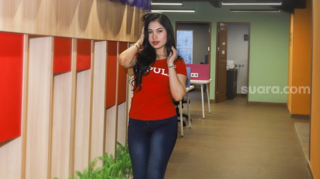 Peserta Finalis Miss Popular 2021 season 3, Aprillia Lee berpose di depan kamera saat sesi pemotretan di kantor redaksi Suara.com, Jakarta Selatan, Jumat (17/9/2021). [Suara.com/Alfian Winanto]