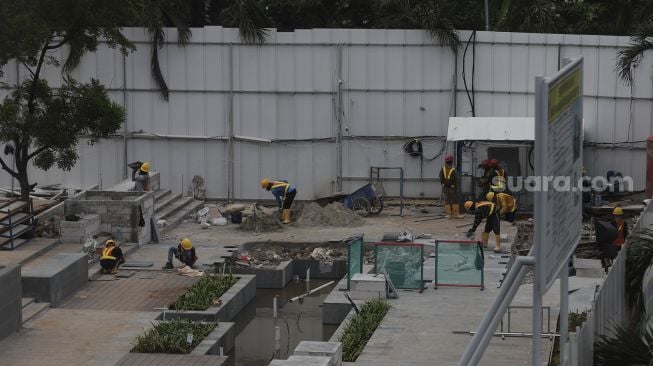 Pekerja menyelesaikan proyek renovasi Gedung Sarinah di Jalan MH Thamrin, Jakarta, Jumat (17/9/2021). [Suara.com/Angga Budhiyanto]