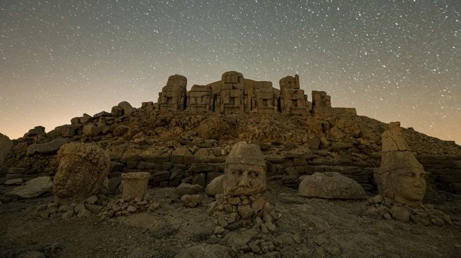 Patung kepala batu besar di situs arkeologi Gunung Nemrut di Adiyaman, Turki, Jumat (17/9/2021). [Yasin AKGUL / AFP]