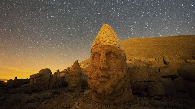 Patung kepala batu besar di situs arkeologi Gunung Nemrut di Adiyaman, Turki, Jumat (17/9/2021). [Yasin AKGUL / AFP]