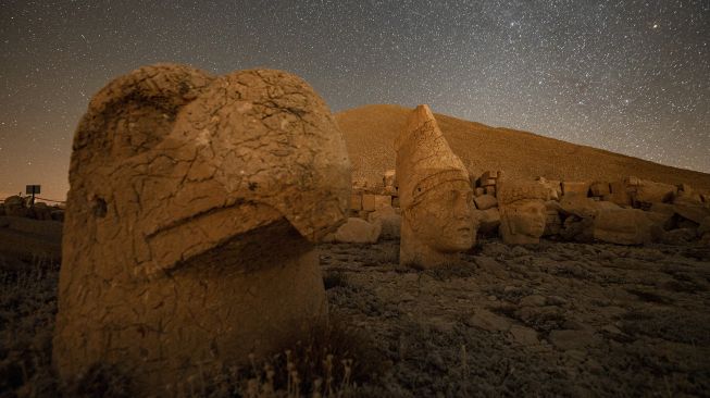 Patung kepala batu besar di situs arkeologi Gunung Nemrut di Adiyaman, Turki, Jumat (17/9/2021). [Yasin AKGUL / AFP]