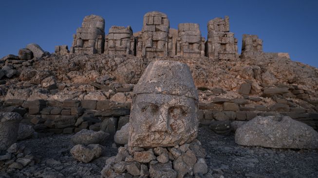 Patung kepala batu besar di situs arkeologi Gunung Nemrut di Adiyaman, Turki, Jumat (17/9/2021). [Yasin AKGUL / AFP]