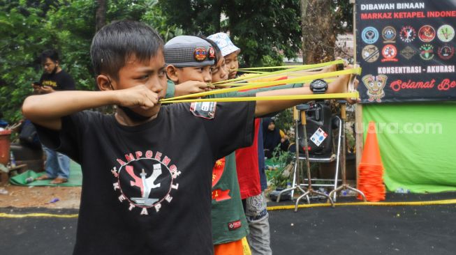 Anak - anak mengikuti kompetisi ketapel di Kampung Ketapel, Ciganjur, Jakarta Selatan, Minggu (19/9/2021). [Suara.com/Alfian Winanto]