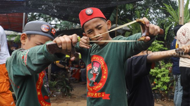 Anak - anak mengikuti kompetisi ketapel di Kampung Ketapel, Ciganjur, Jakarta Selatan, Minggu (19/9/2021). [Suara.com/Alfian Winanto]