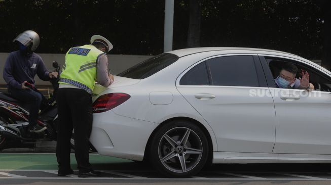 Polisi melakukan penindakan terhadap pengendara yang melanggar lalu lintas saat Operasi Patuh Jaya 2021 di kawasan Bundaran Hotel Indonesia, Jakarta, Senin (20/9/2021). [Suara.com/Angga Budhiyanto]