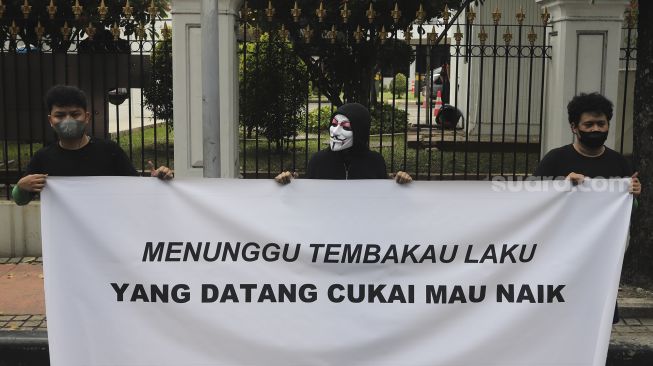 Massa yang tergabung dalam masyarakat pertembakauan membentangkan spanduk saat menggelar aksi unjuk rasa di luar Istana Merdeka, Jakarta, Senin (20/9/2021). [Suara.com/Angga Budhiyanto]