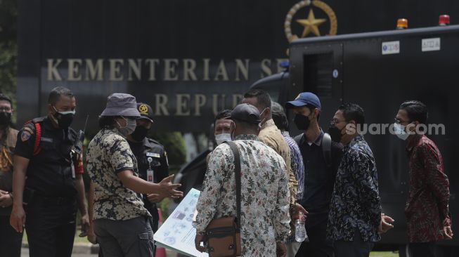 Perwakilan massa aksi masyarakat pertembakauan berdiskusi dengan petugas keamanan saat menggelar aksi unjuk rasa di luar Istana Merdeka, Jakarta, Senin (20/9/2021). [Suara.com/Angga Budhiyanto]