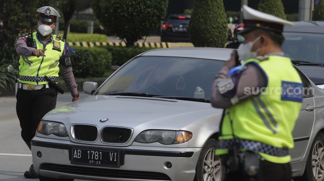 Polisi melakukan penindakan terhadap pengendara yang melanggar lalu lintas saat Operasi Patuh Jaya 2021 di kawasan Bundaran Hotel Indonesia, Jakarta, Senin (20/9/2021). [Suara.com/Angga Budhiyanto]