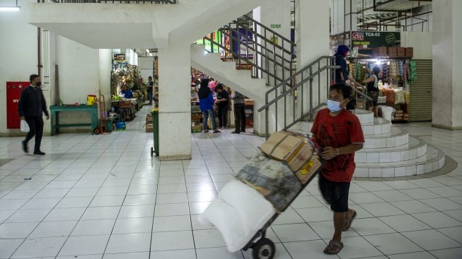 Pekerja mengangkut barang dagangan di Rumah Susun Pasar Rumput, Manggarai, Jakarta, Senin (20/9/2021). ANTARA FOTO/M Risyal Hidayat