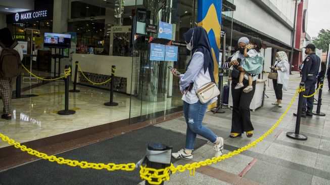 Pengunjung mengendong anaknya saat berkunjung ke pusat perbelanjaan Bandung Indah Plaza, Bandung, Jawa Barat, Selasa (21/9/2021).  ANTARA FOTO/Novrian Arbi
